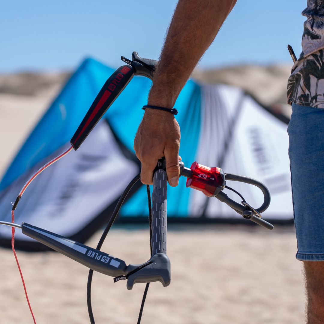 PLKB Compass LEI kitebar. Man die de kitebar vasthoudt op het strand.